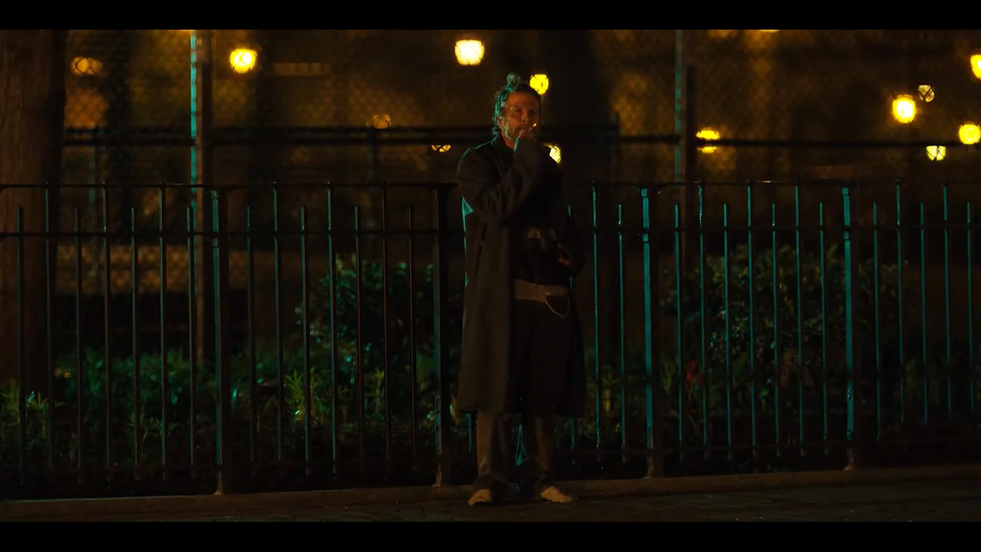 Horse standing in front of a fence, smoking.